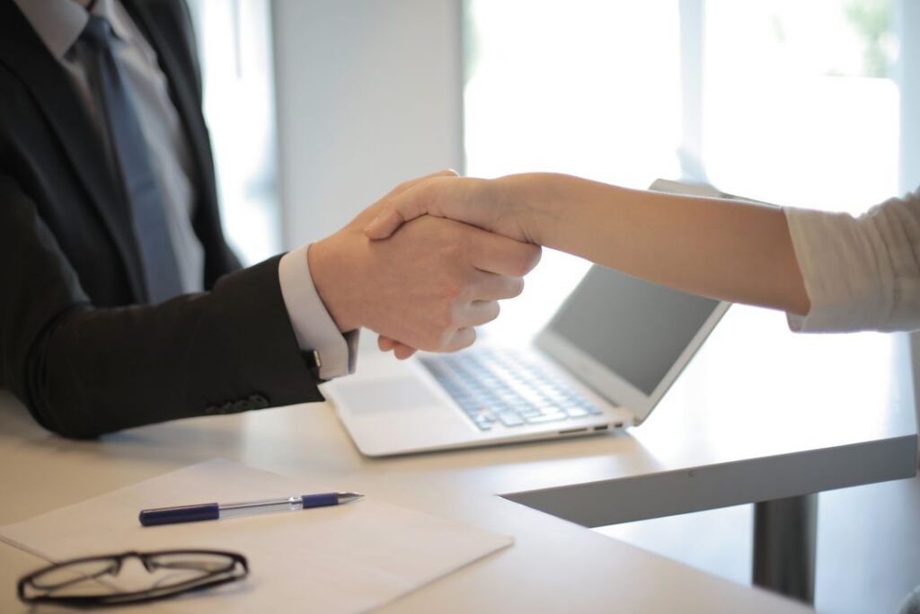 Two people shaking hands for payroll services