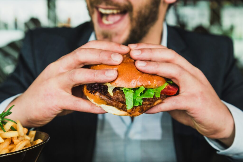 man eating burger and fries