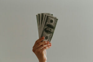 Hand holding up a stack of twenty dollar bills